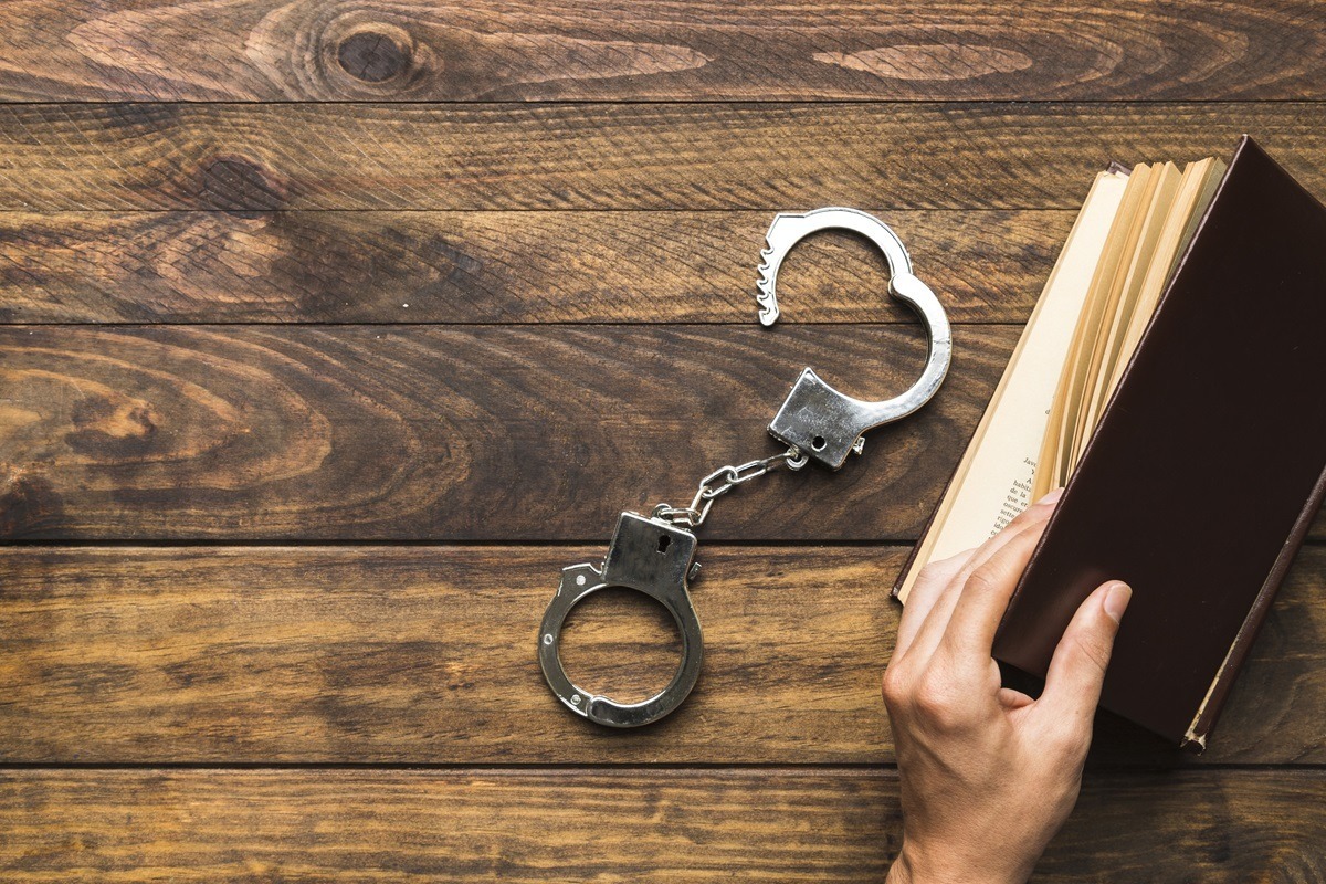 Algema para pris&atilde;o preventiva ao lado de livro (Foto: Freepik)